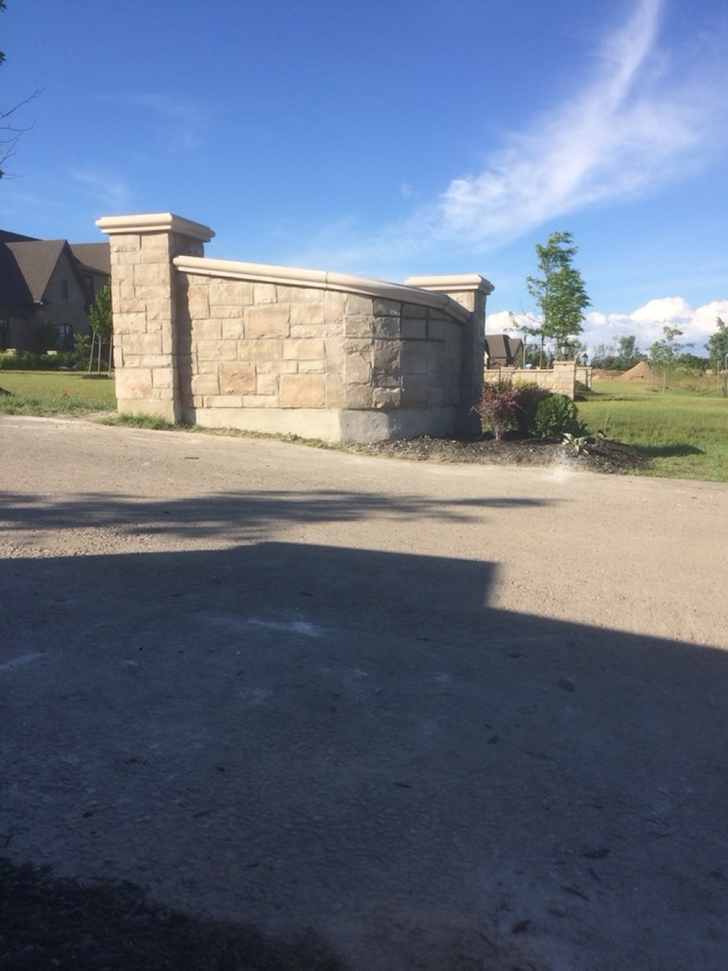 Stone entry wall beside a road